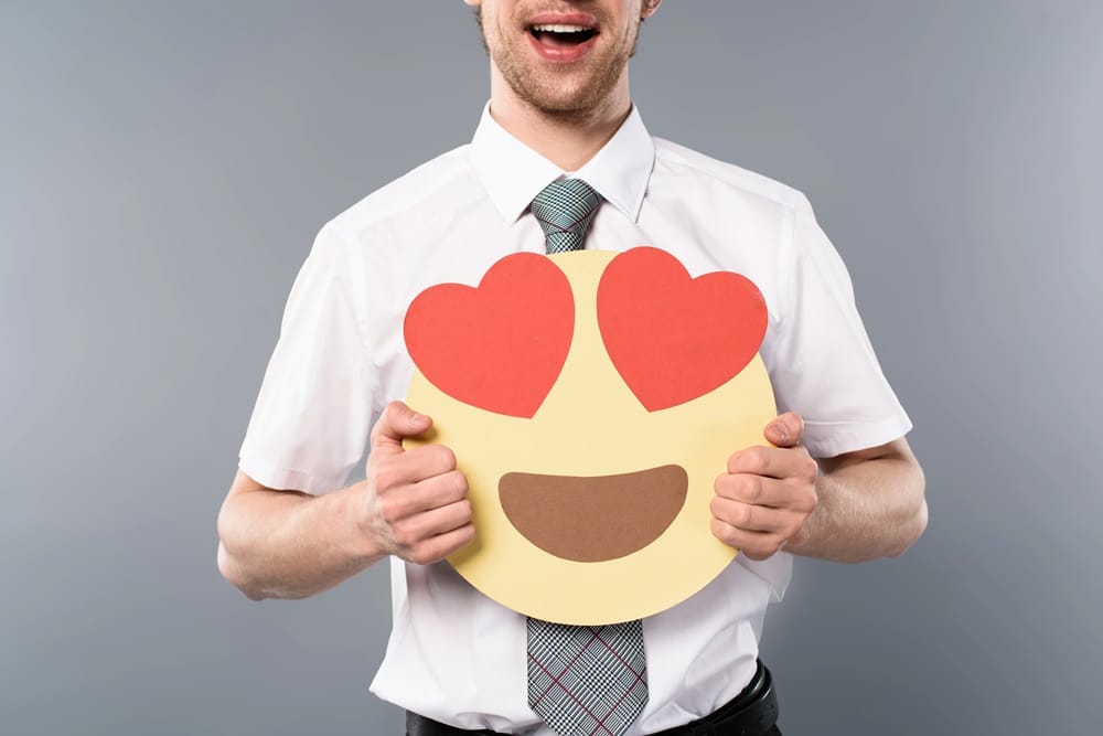 Man holding a love-eyes emoji sign